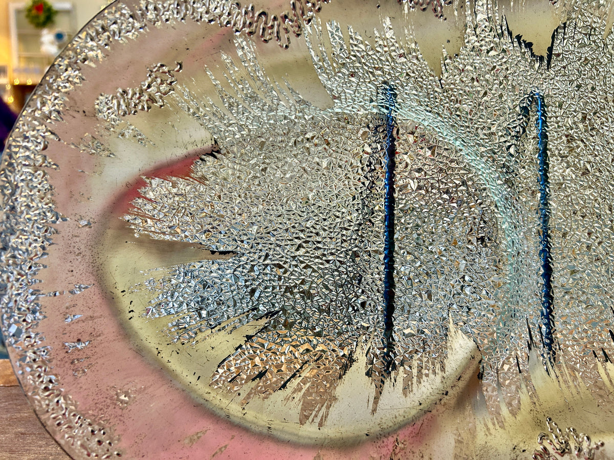 Silver round divided platter close-up with speckled splash texture and central divider