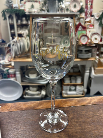 Stemmed clear wine glass with gold “Cheers” script
