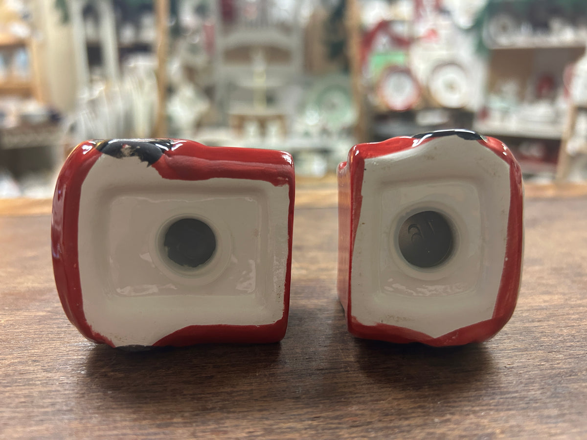 Two red-and-white ceramic truck figurines from the back, circular openings visible.