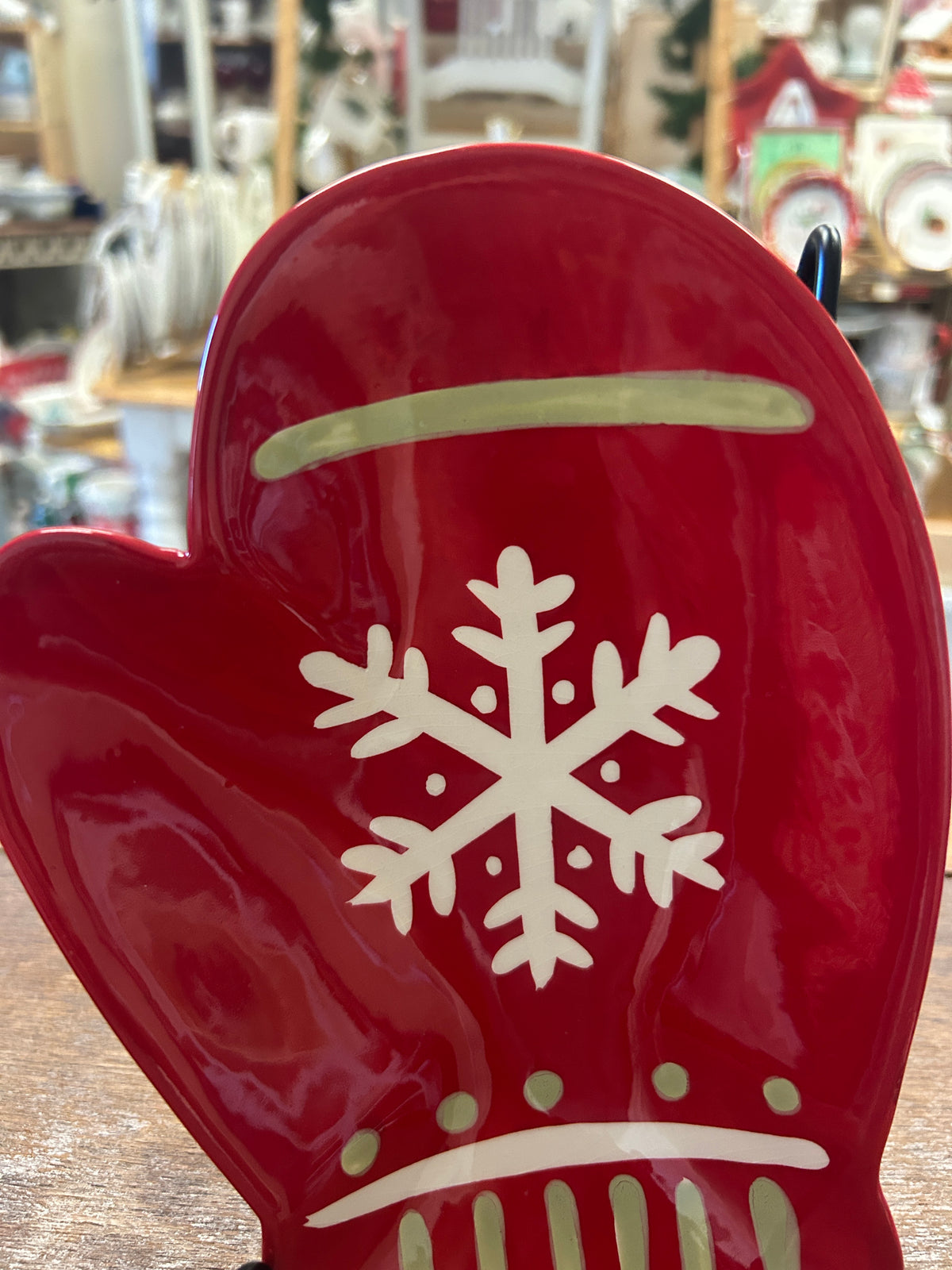 Red mitten-shaped decorative plate with raised white snowflake and striped trim design