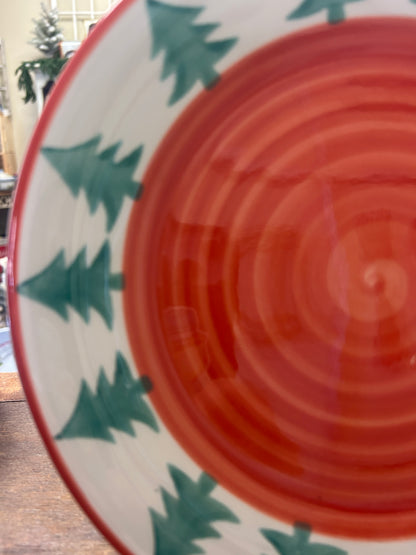 Orange spiral Christmas plate with green pine tree pattern and red rim edge