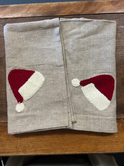 Set of 2 linen-style napkins with red and white Santa hat appliques, folded