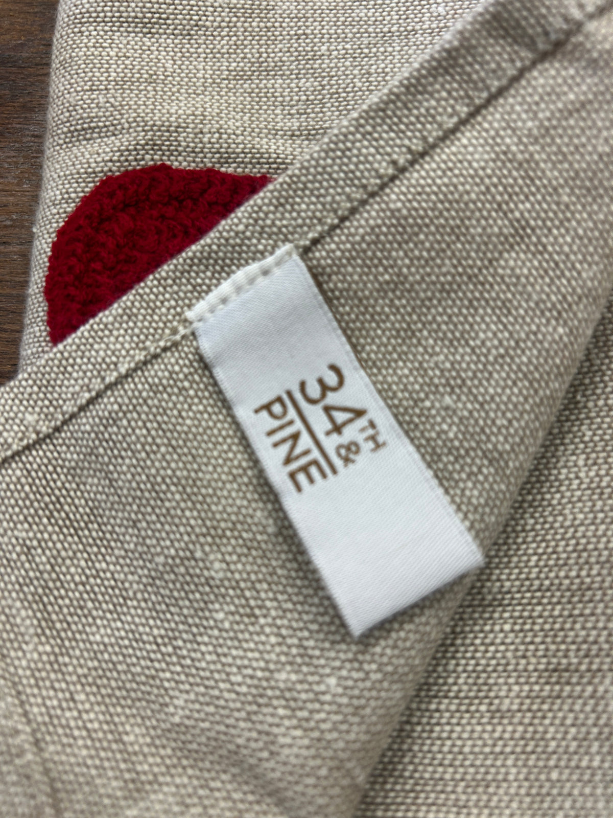 Linen-style napkin label on folded edge with red Santa hat applique