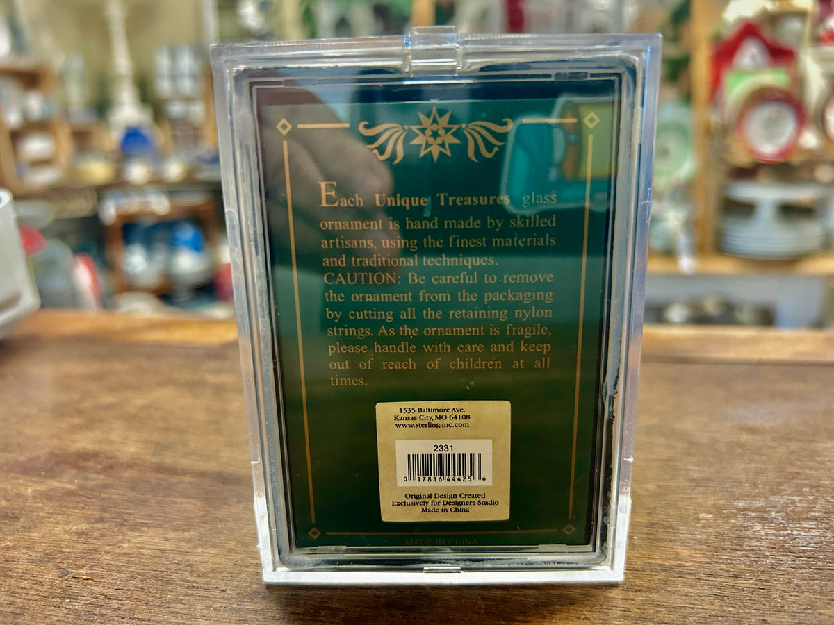 Back of Santa glass ornament in clear box with printed care text and barcode