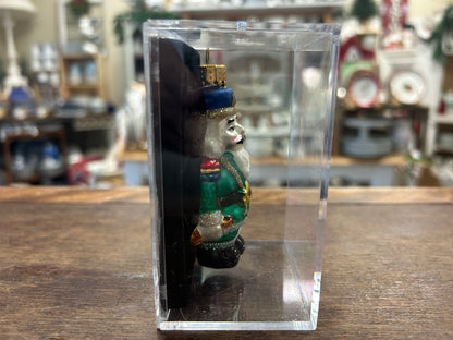 Nutcracker ornament in clear box, side view of blue hat soldier in green coat