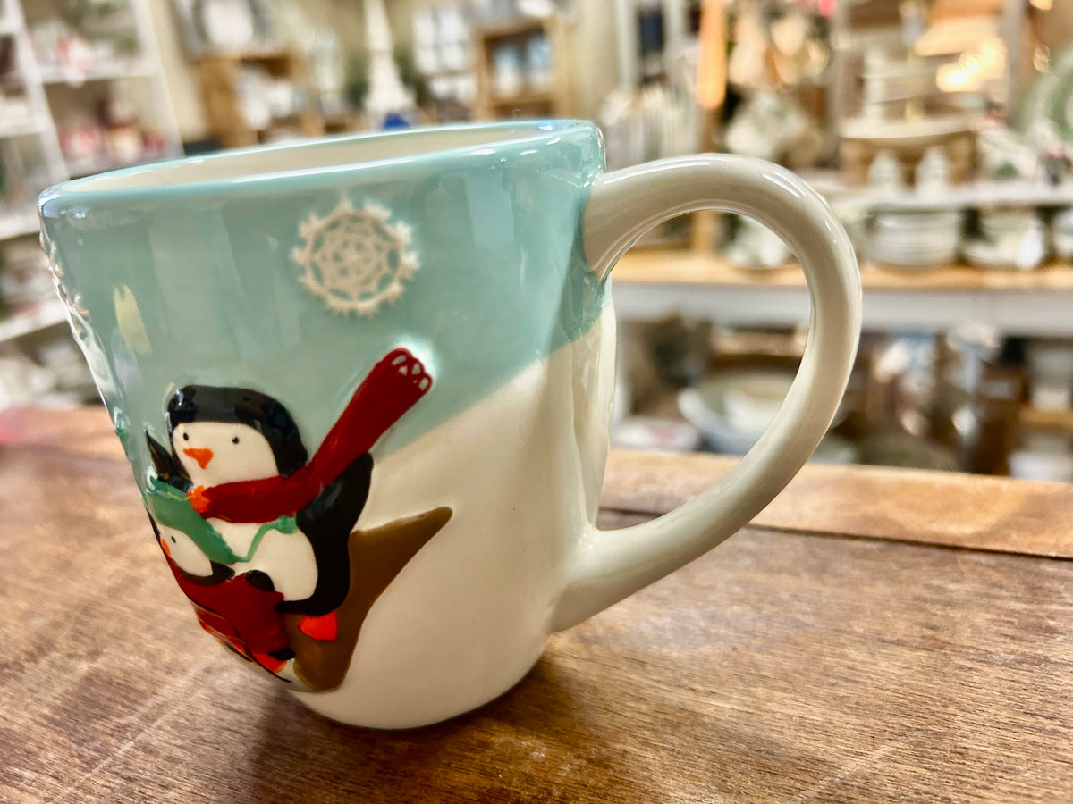 Blue and white Christmas mug featuring a penguin in a red scarf holding a cane