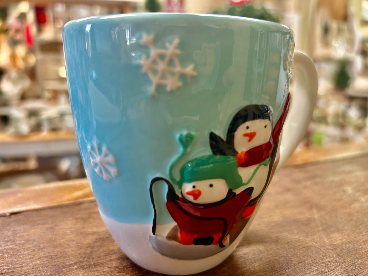 Blue and white Christmas mug with two penguin figures and snowflake details