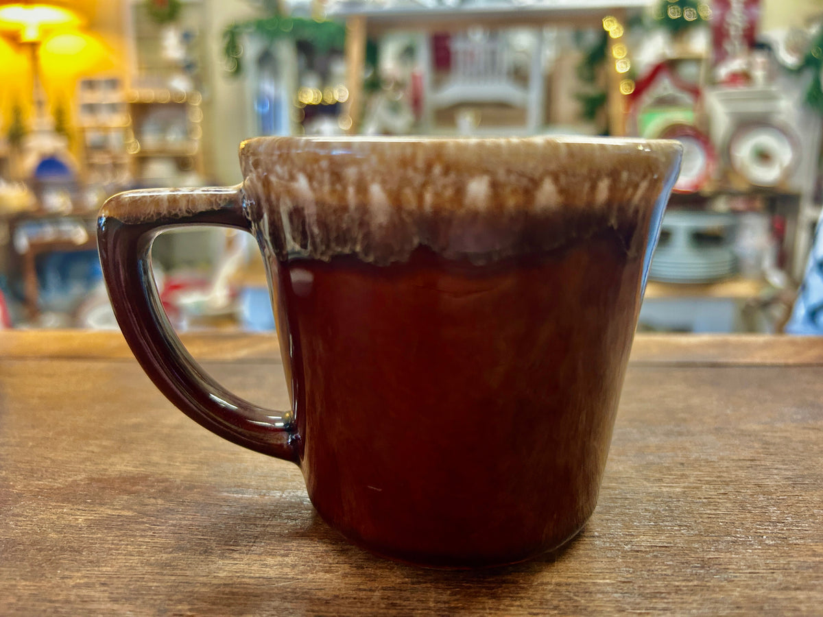 Brown ceramic drip mug with curved handle and speckled rim