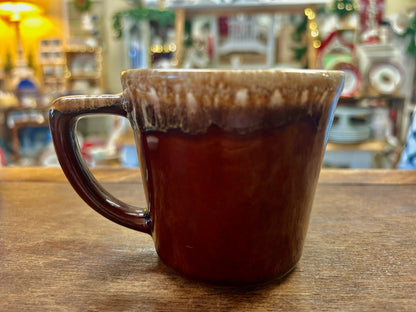 Brown ceramic drip mug with curved handle and speckled rim