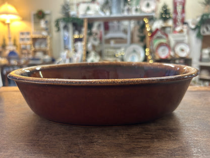 Oval brown glazed baking dish with high sides and speckled gold drip rim