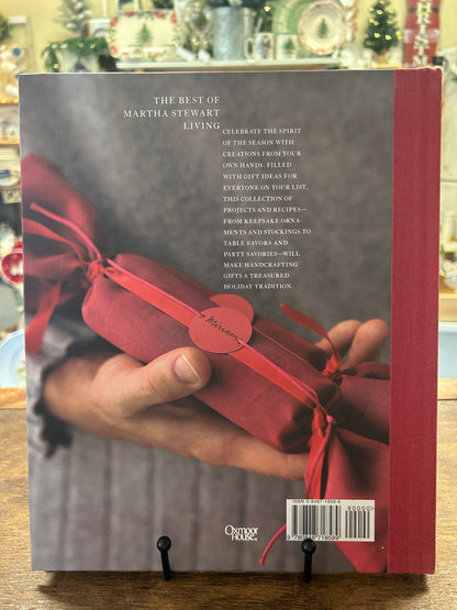 Holiday crafts keepsakes hardcover book back cover with hand holding red ribbon box