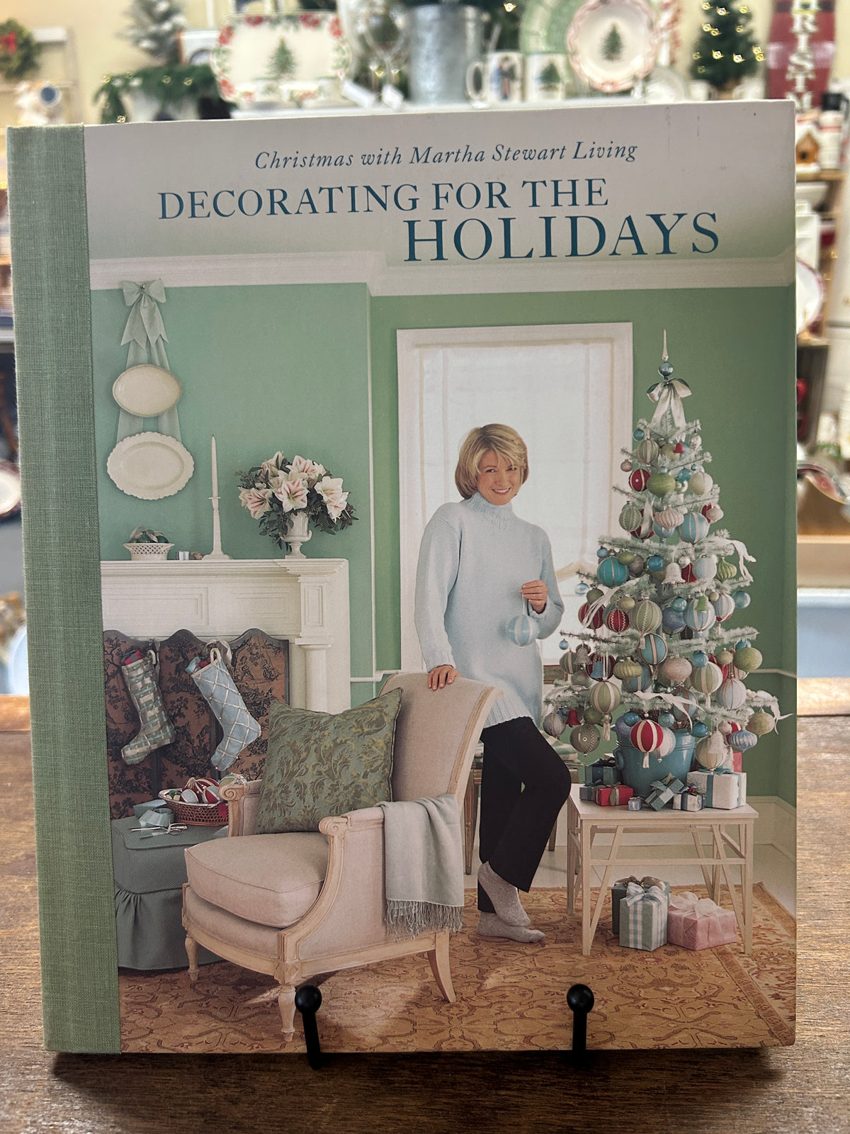 Holiday decorating book with illustrated front cover, woman by a Christmas tree