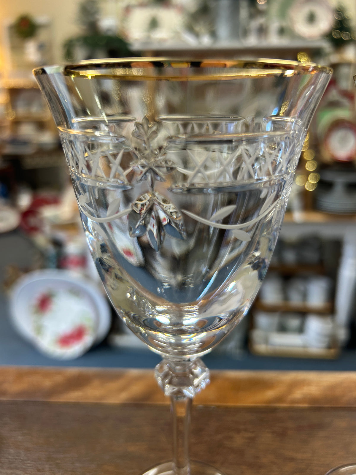 Clear crystal wine glass with gold rim and etched decorative pattern