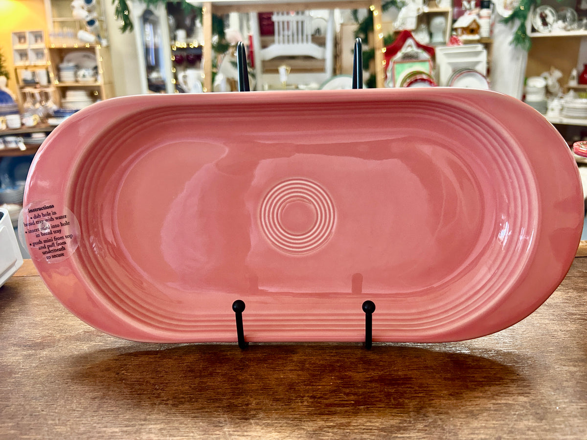 Pink oval ceramic serving platter with concentric circle embossed center