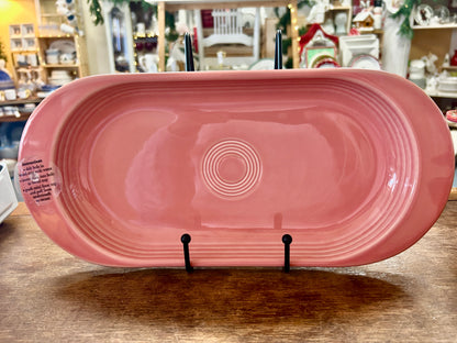 Pink oval ceramic serving platter with concentric circle embossed center