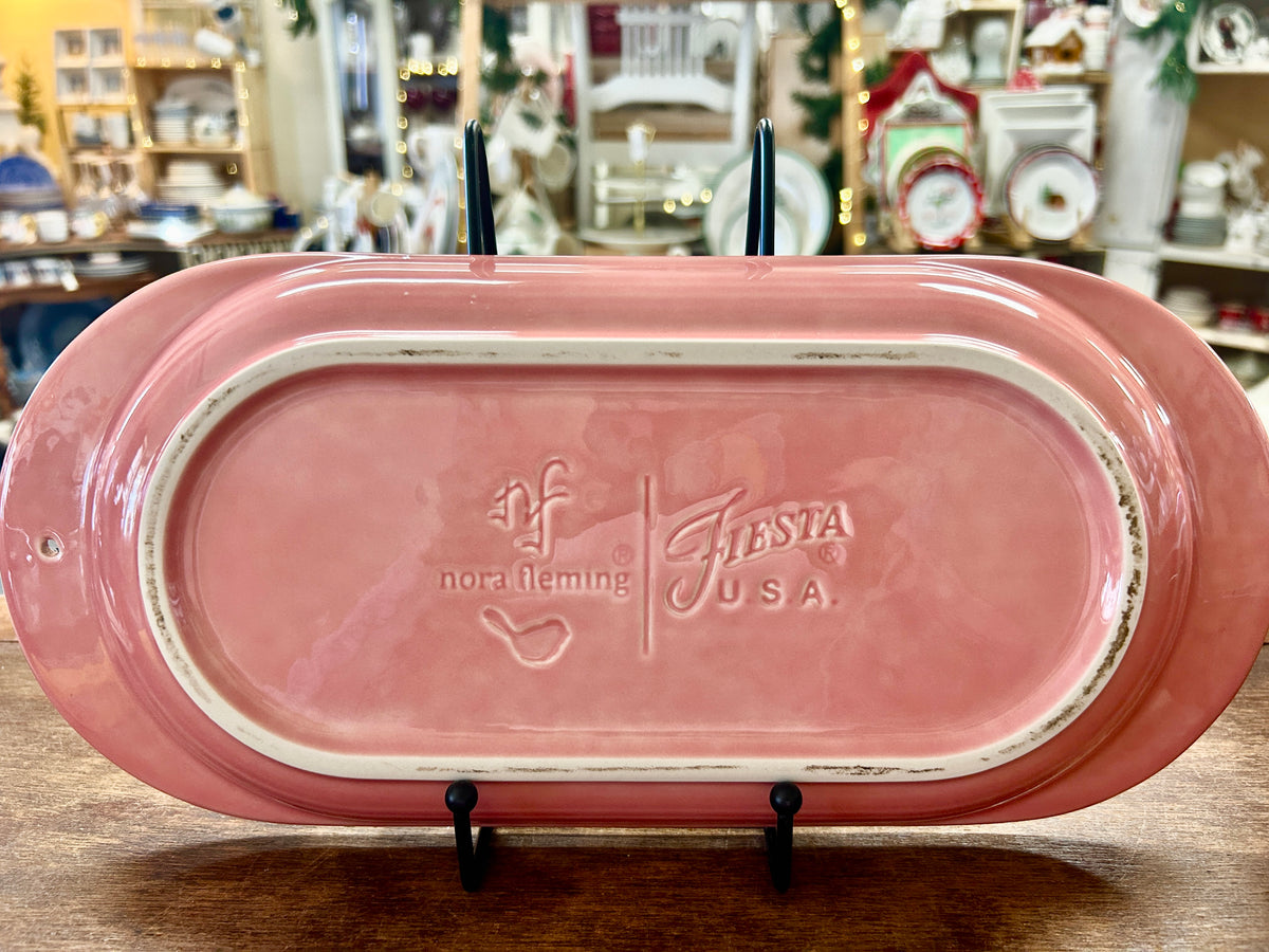 Pink ceramic serving platter underside with Nora Fleming and Fiesta USA marks