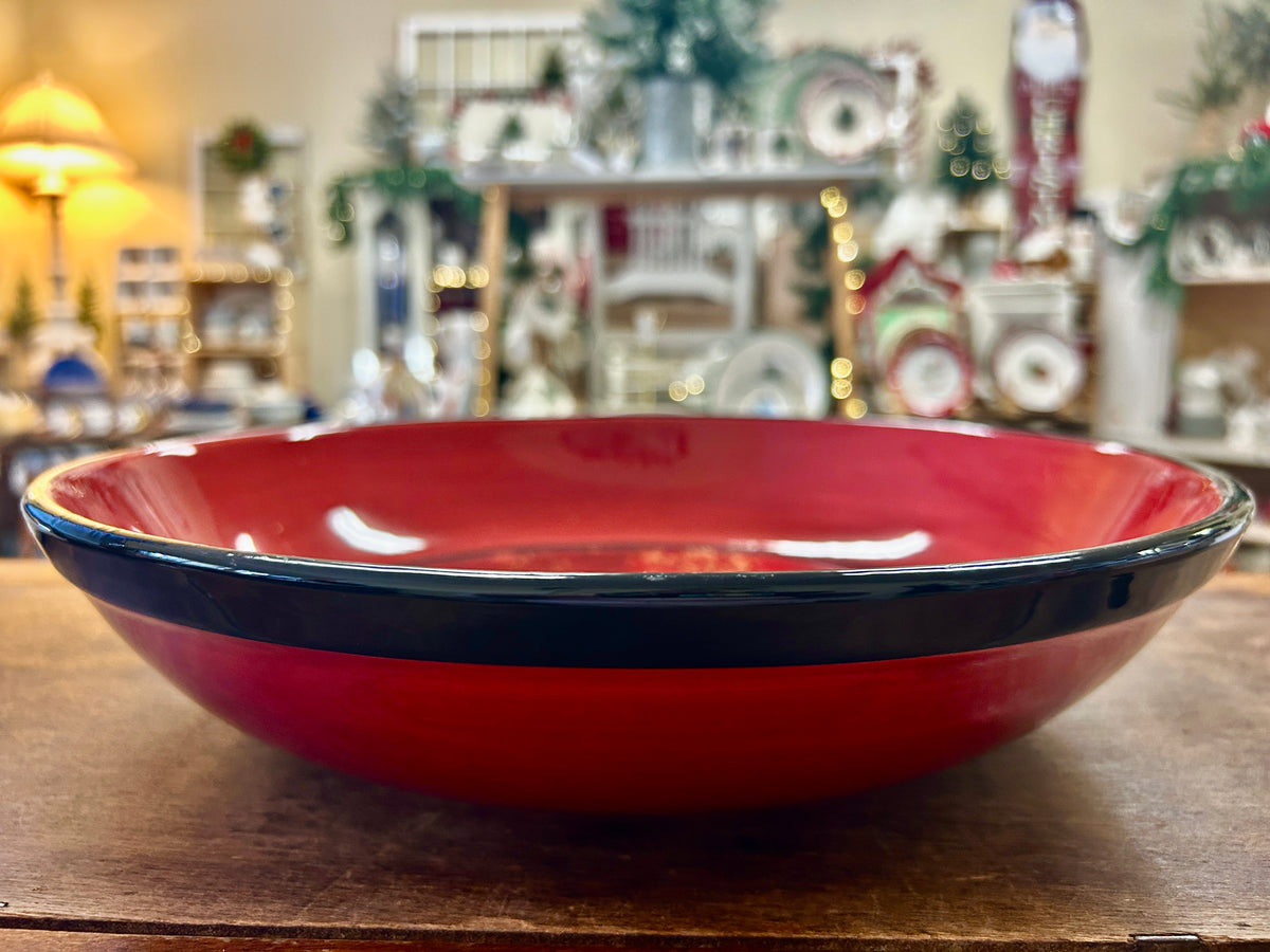 Red ceramic bowl with dark blue rim band and glossy finish