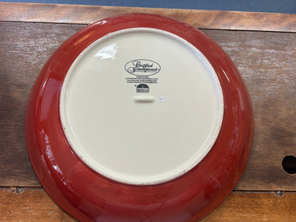 Red ceramic bowl underside with white center and small maker stamp