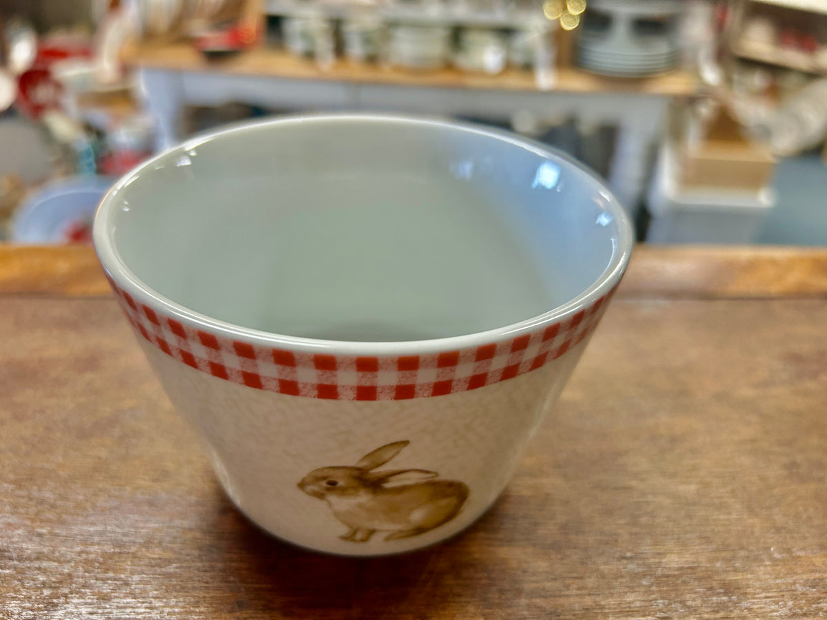 Pink and white ceramic bowl with red gingham rim and standing bunny rabbit design