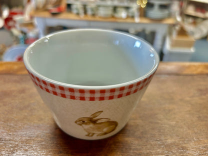 Pink and white ceramic bowl with red gingham rim and standing bunny rabbit design