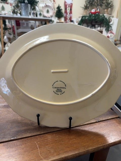Yellow oval ceramic platter underside with brand mark and center guide slot handle